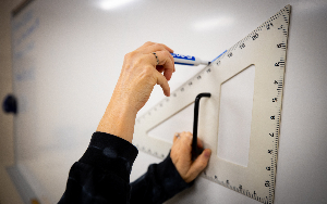  A teacher uses a protractor on the whiteboard.